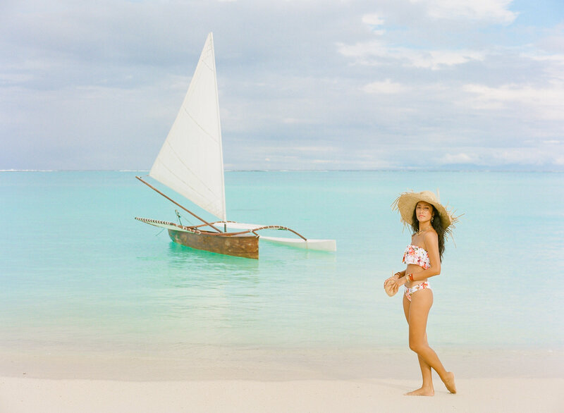 beautiful woman in swimsuit at the Brando Tetiaroa with the iconic boat
