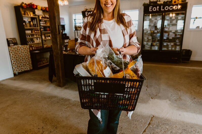 Person holding basket of foods grocery shopping