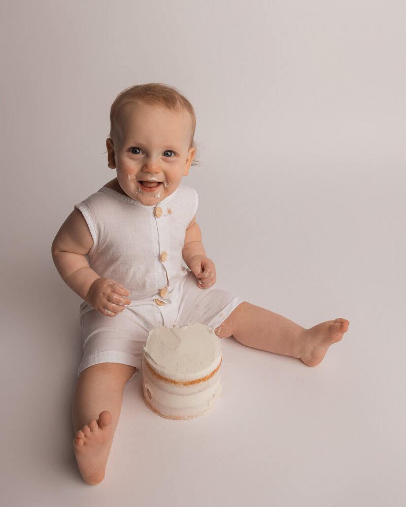 baby smiling with  cake in studio