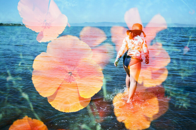 double exposure of california poppies with a girl in a swimsuit wading through san francisco bay