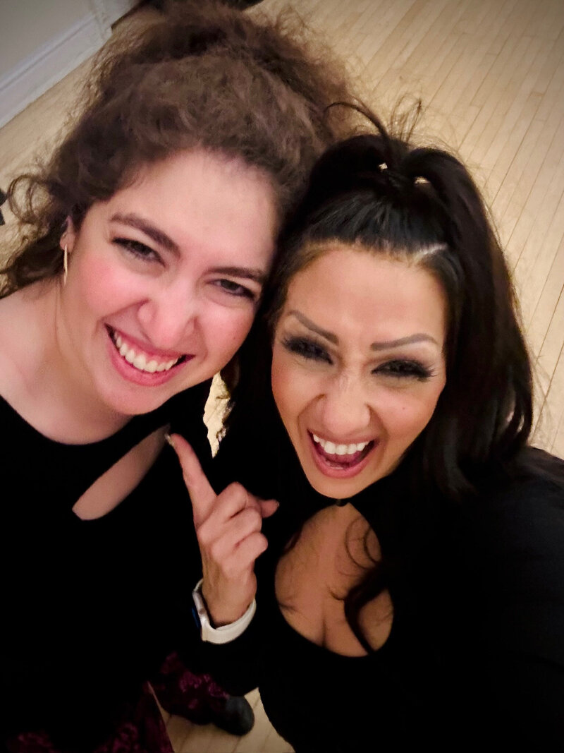 Charizma team members Nicole and Kim sharing a joyful moment at an event