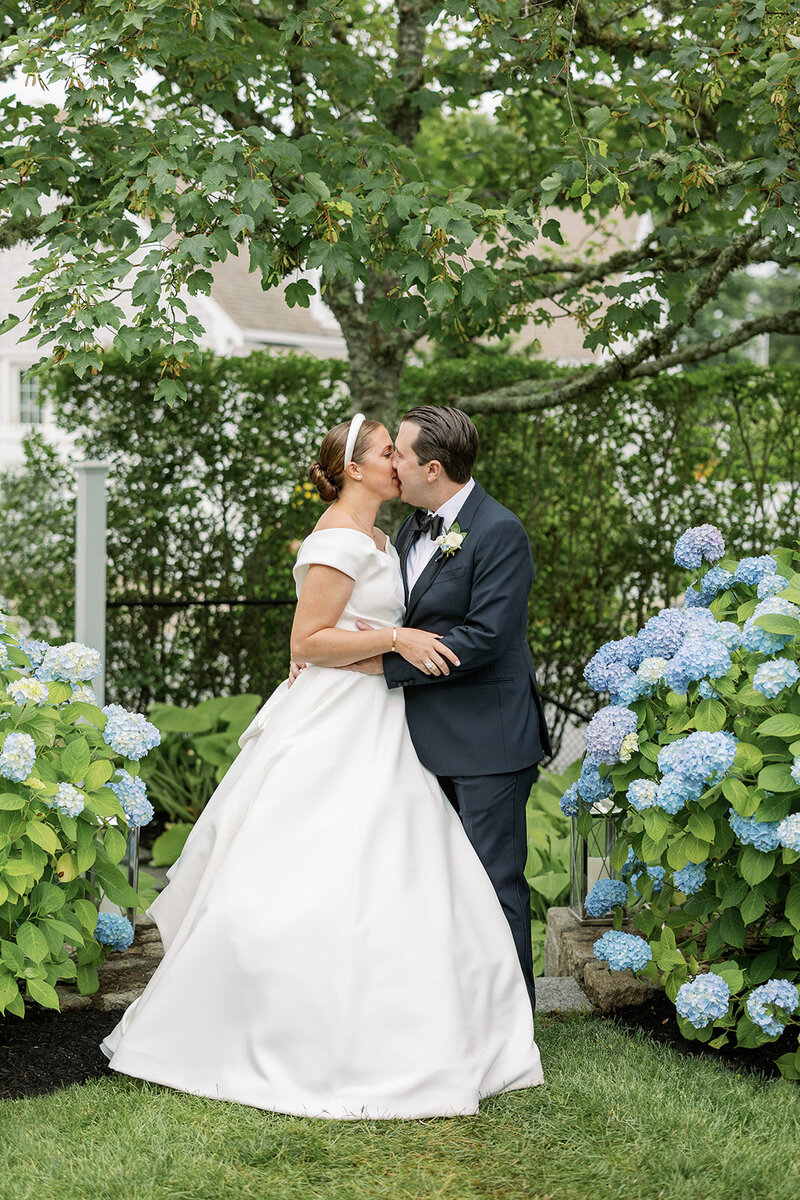 Bride and Groom Kissing with Blue Hydrangeas