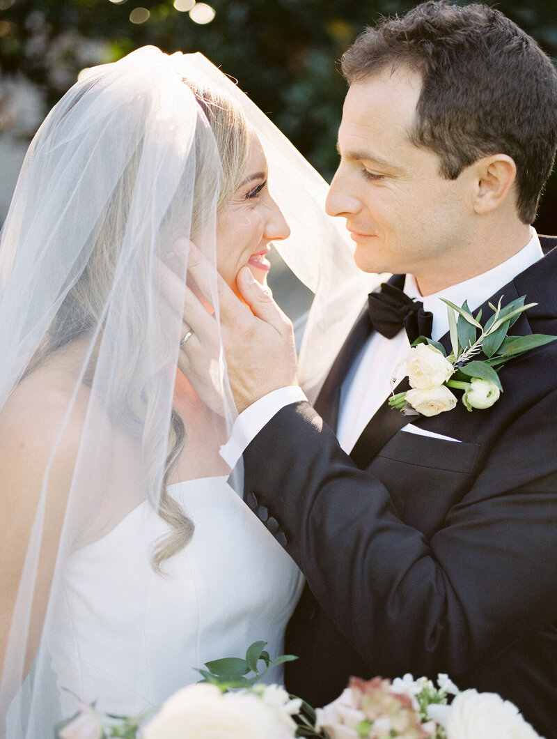 A groom touching his bride's  face