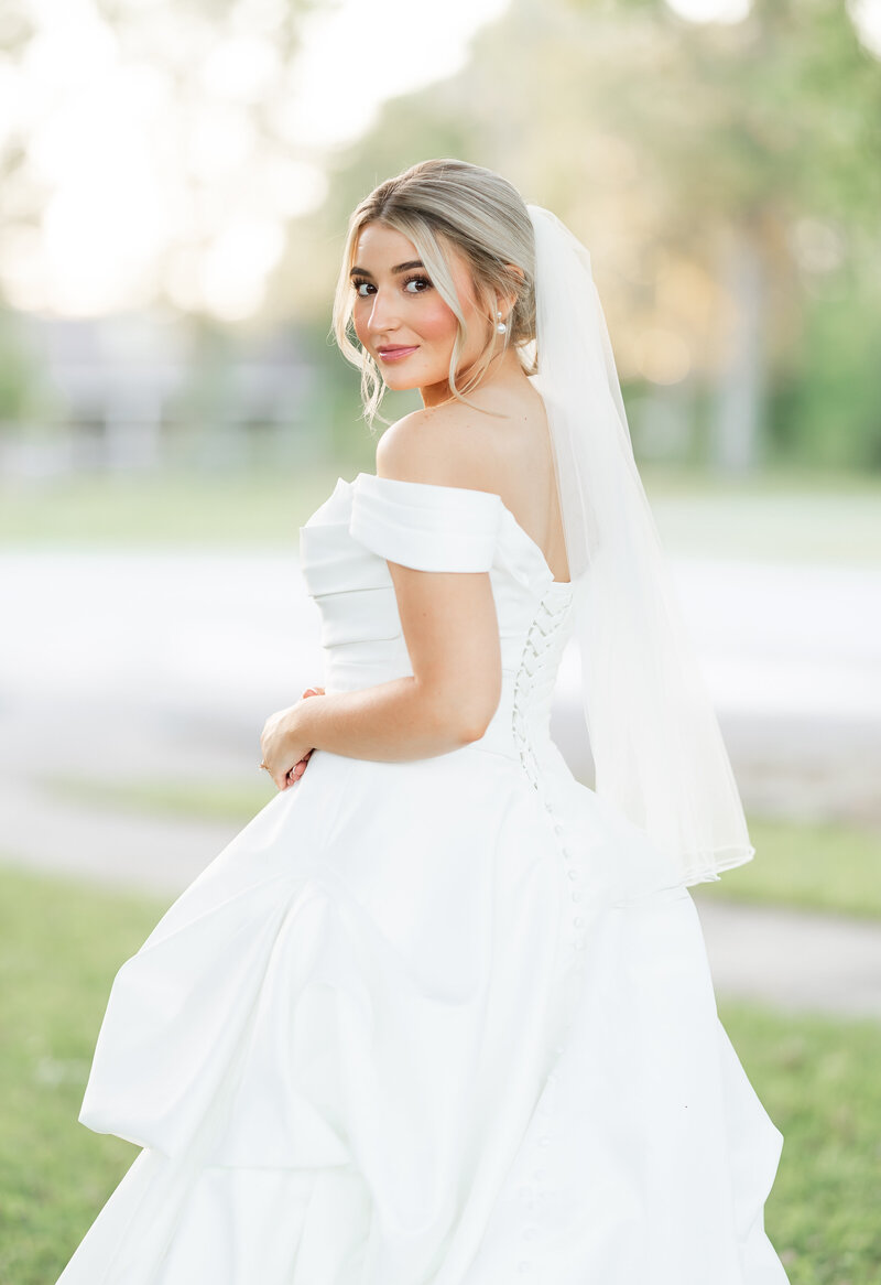 Tallahassee bride posing standing in her wedding dress.