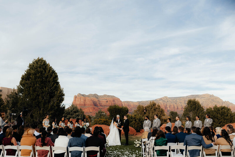 Arizona wedding photographer captures the guests seated and looking on as the bride and groom exchange vows