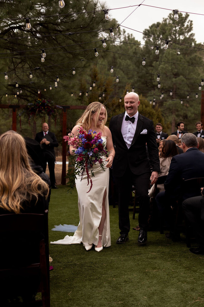 Newlywed couple walking down the aisle in a forest setting during their Utah elopement, captured by Lamblight Photography