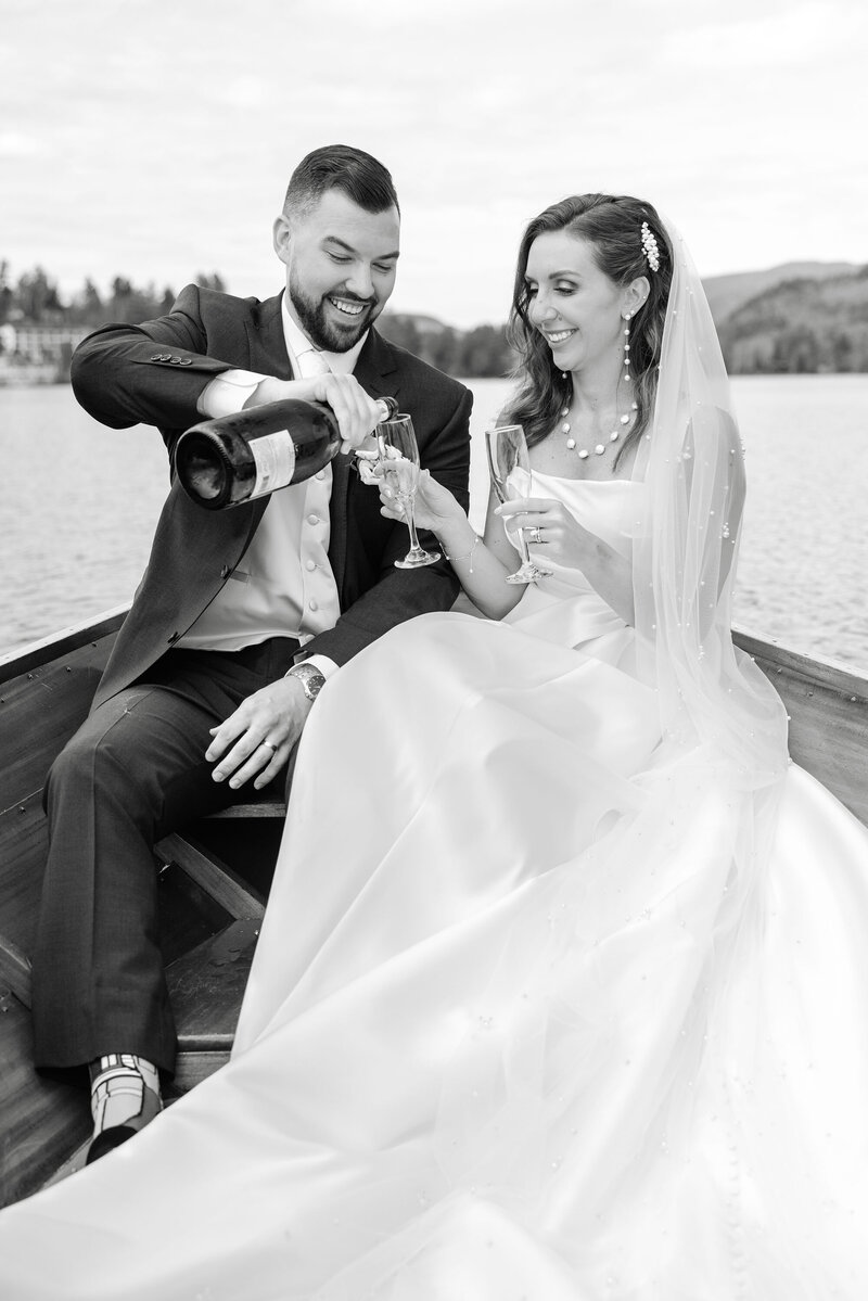 Bride and groom pouring champagne after lake placid wedding
