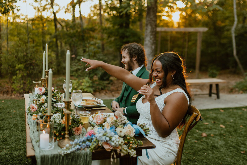 husband and wife smile at sweetheart table