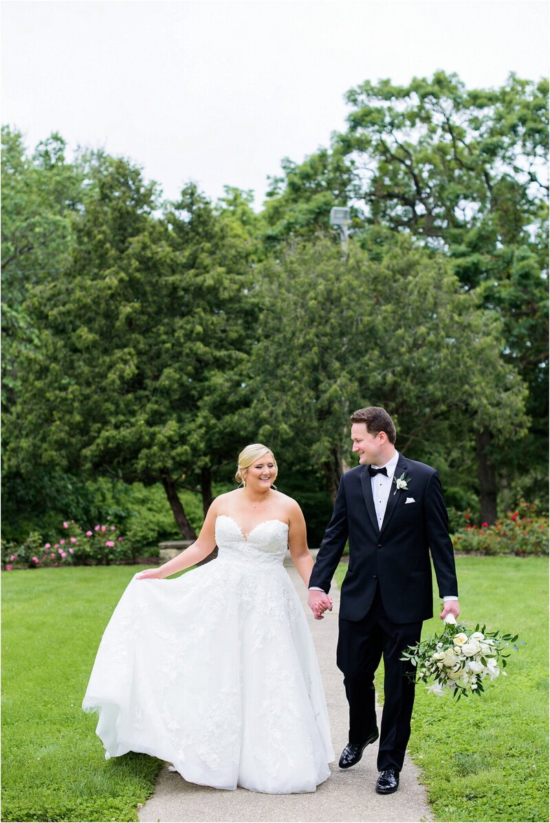 Bride and Groom strolling through a local rose garden