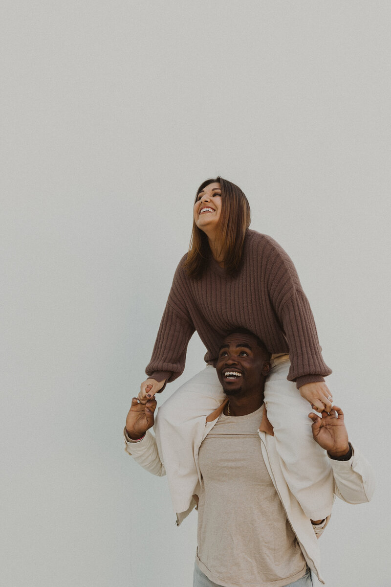 man holding woman on his shoulders