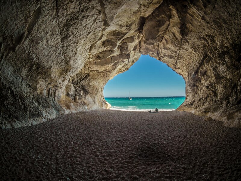 Image of view from inside a beach cave looking out at the beach
