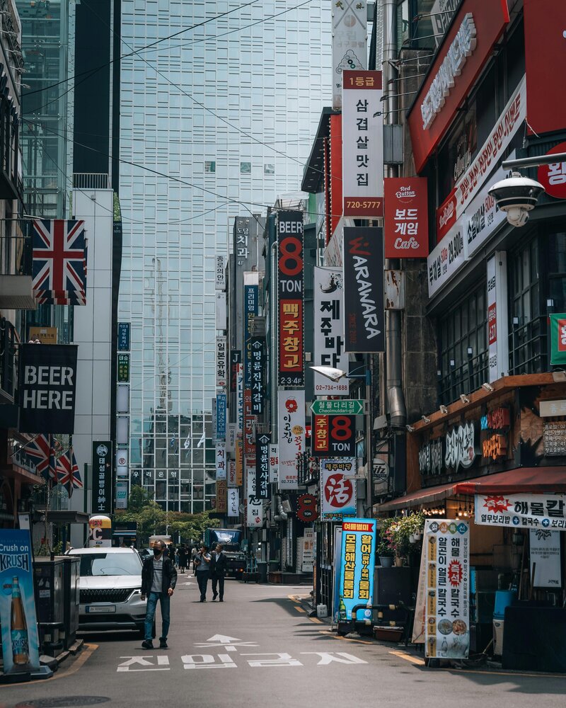 Busy Korean shopping street lined with signage and storefronts