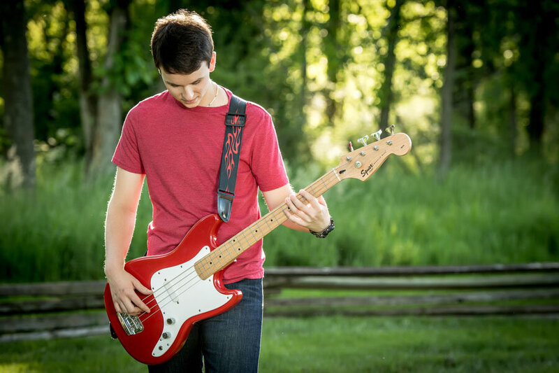 boy outside with red guitar