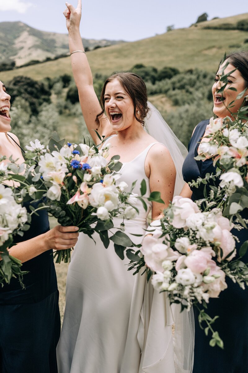 a bride cheers on her wedding day at mt vernon lodge in akaroa
