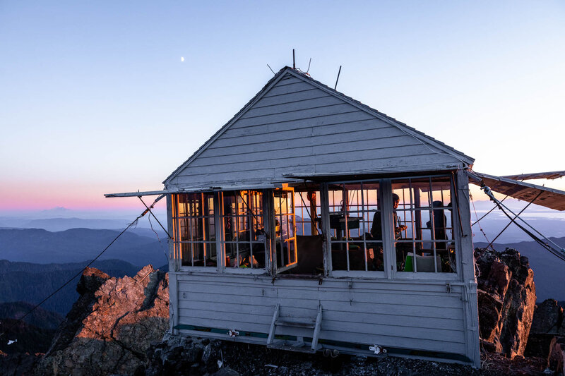 Sunset at a mountain fire lookout on top of a peak