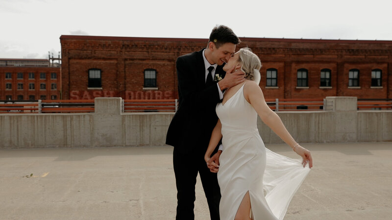 Iowa Wedding Videographer Husband kisses wife on rooftop in Dyersville