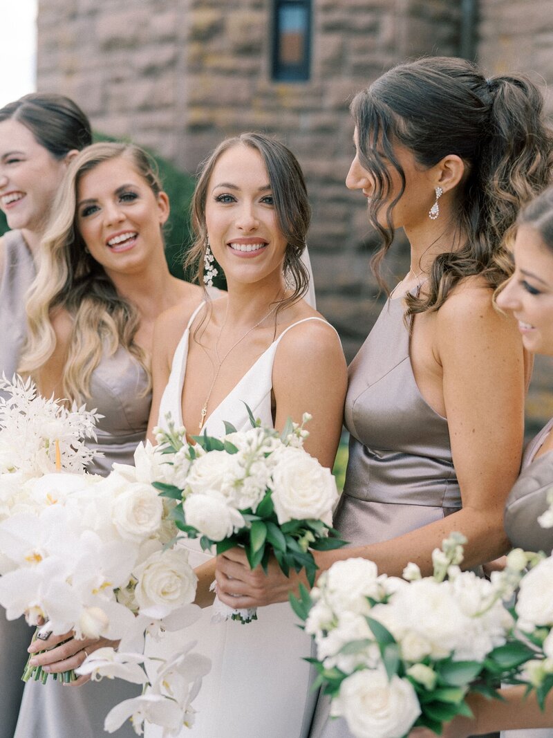 Bride with bridesmaids in purple gowns and white bouquets