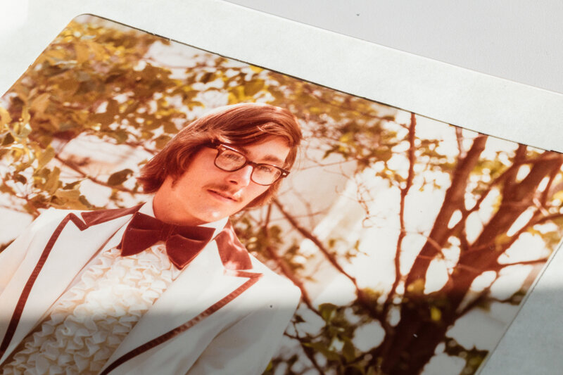 A photo of a wedding album page featuring a groom from the 1970s, showcasing timeless memories.