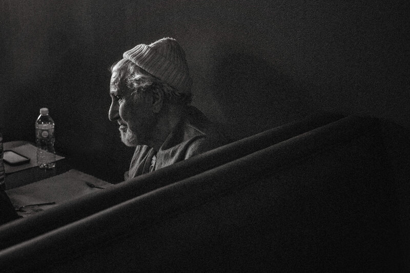 elderly man with grey hair and toque in beautiful window light