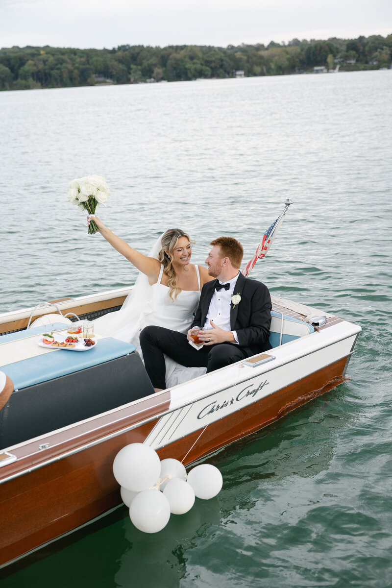 Bride and groom sharing a romantic kiss on a yacht in the lake, captured by a Madison wedding photographer.