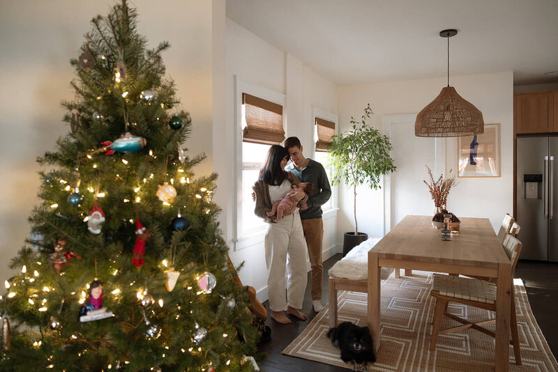 mother and father holding newborn baby at home