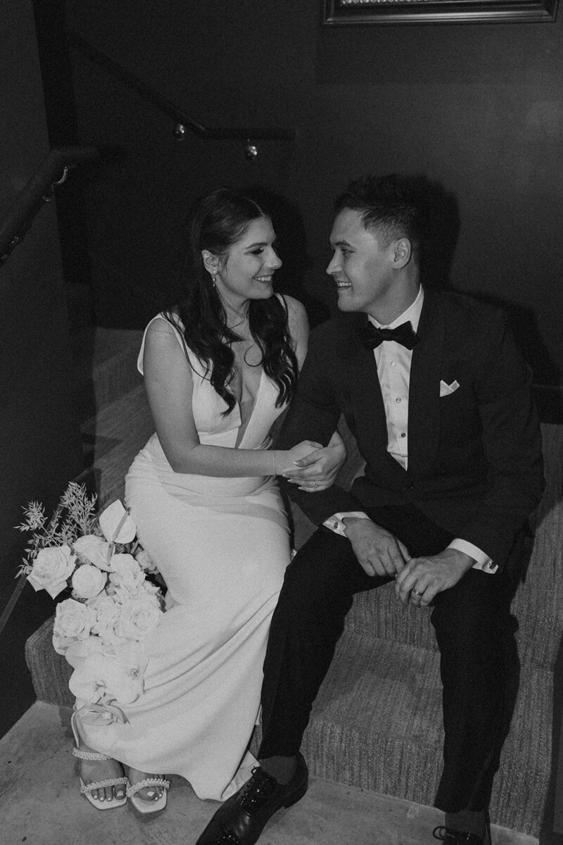 bride and daughter on wedding day in front of a beautiful arch of flowers with a bridal bouquet and flower crown