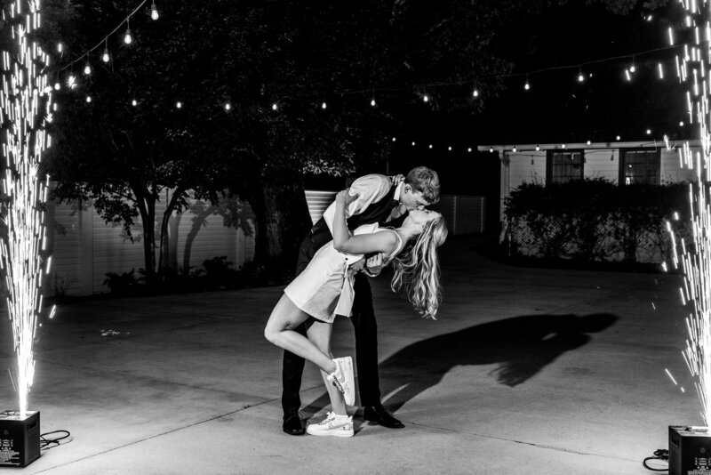 Spring wedding at WinMock at Kinderton, designed by Charming Carolina — bride and groom sharing a dramatic dip and kiss between two cold sparks during their grand exit.