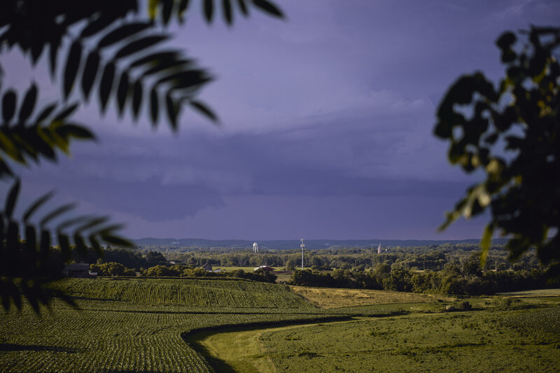 Dark clouds over a field and small midwest town