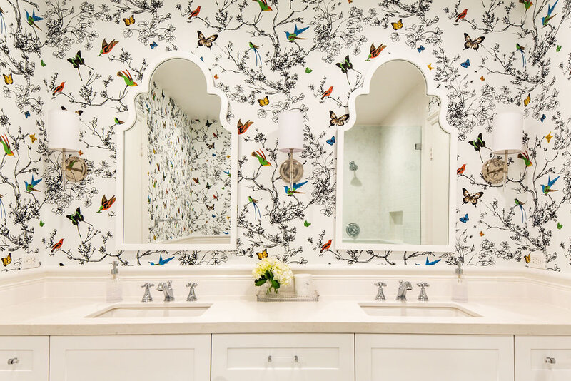 Bathroom with white arch mirrors and Schumacher Birds and Butterflies wallpaper