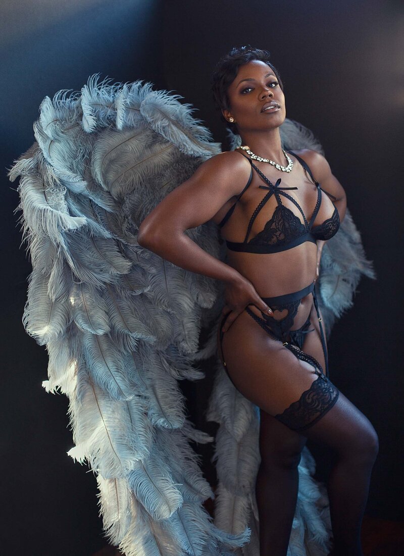 woman posing in lingerie with angel wings and lingerie on a background with natural light