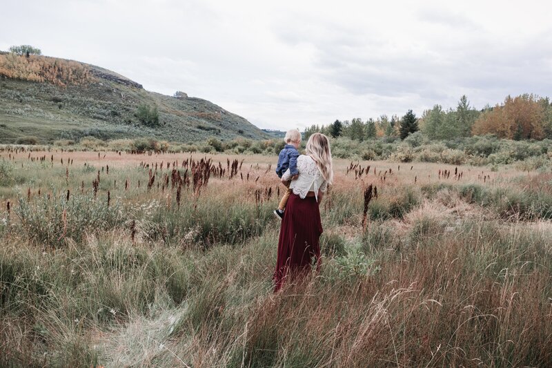 Newly engaged couple dance in an Alberta foothills field