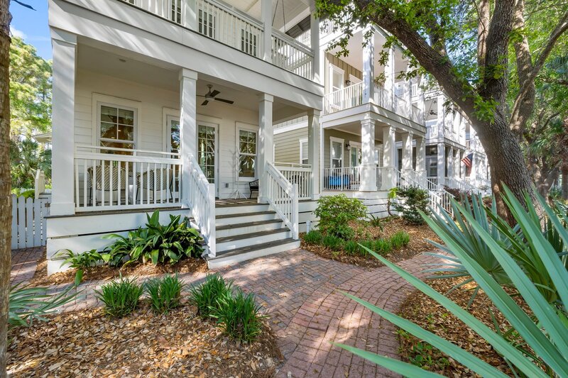Charming front porch with white railings and lush landscaping at Tangerine Dream in Carillon Beach