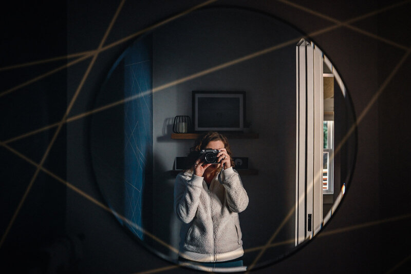 double exposure self-portrait taken in mirror using the lines of the wallpaper to frame subject in mirror