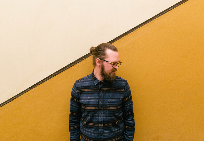 wedding videographer headshot against yellow wall