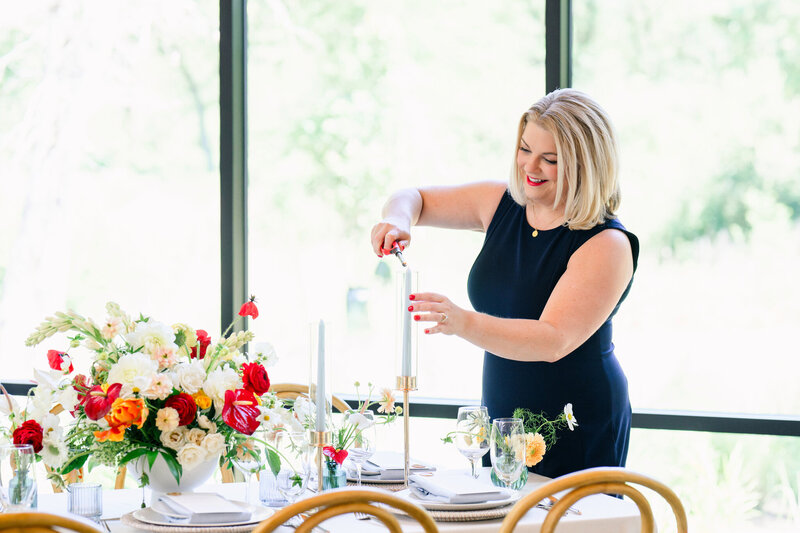 Wedding planner lighting taper candles during wedding setup, showcasing elegant design and expert planning in Dripping Springs, Texas.