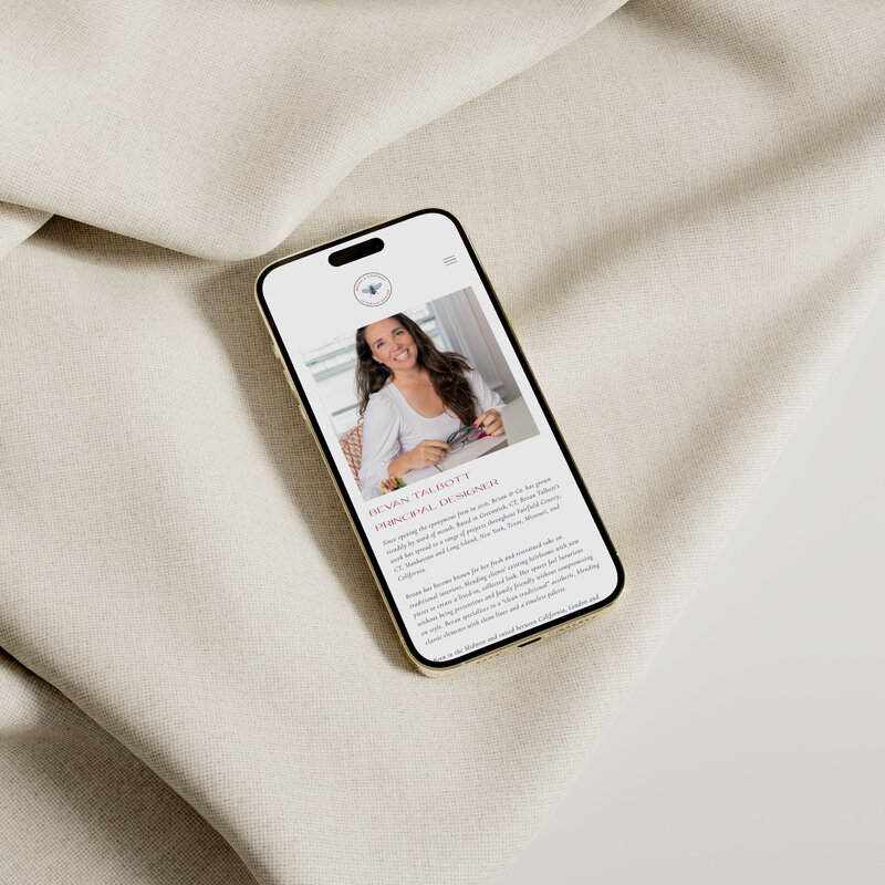 Bevan & Company Interior Design about page mocked up on iPhone laying on cream textile