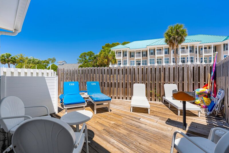 Private fenced patio at Beach Cabana featuring loungers, a grill, and sun-soaked vibes, perfect for Panama City Beach vacation rentals near 30A.
