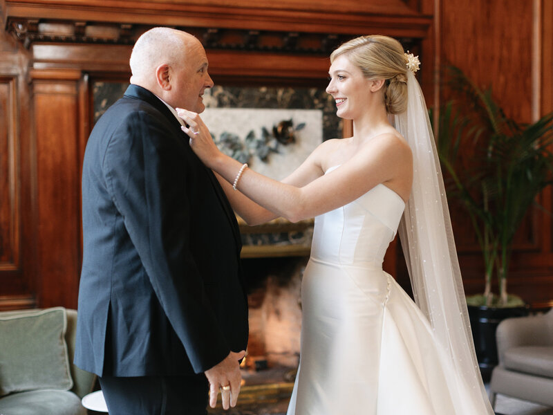 Modern bride wearing her Grandma's vintage heirloom wax flower bridal crown while adjusting the bowtie on the father of the bride