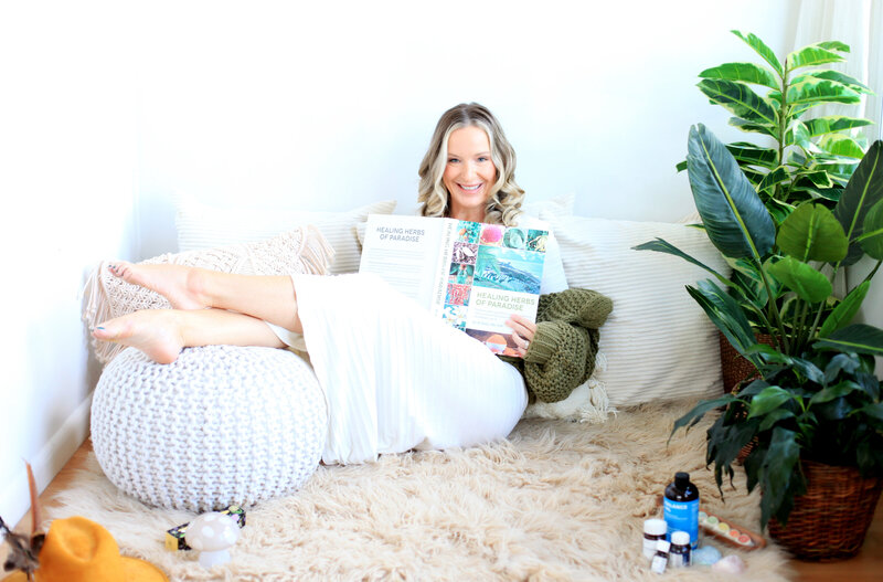 Austyn McAllister reading a holistic medicine book at home, promoting natural healing and personalized wellness care