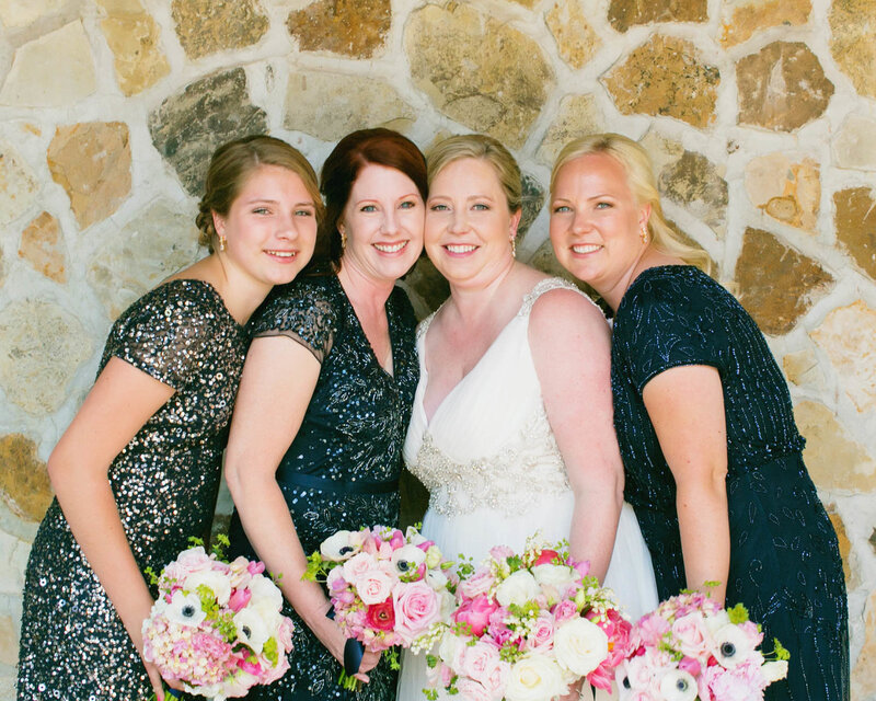 Bride stands in the middle of three bridesmaids all holding bouqutes