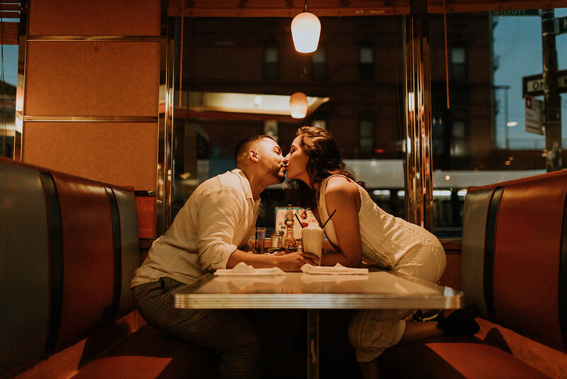 Couple kissing at a diner booth
