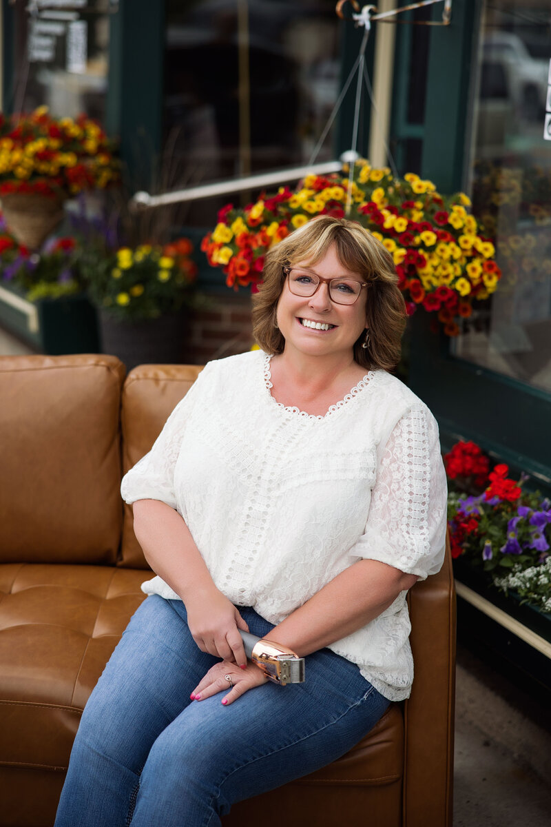 Portrait of Nikki Cairns, professional stylist at Intrigue Salon, holding a hairdryer in the salon