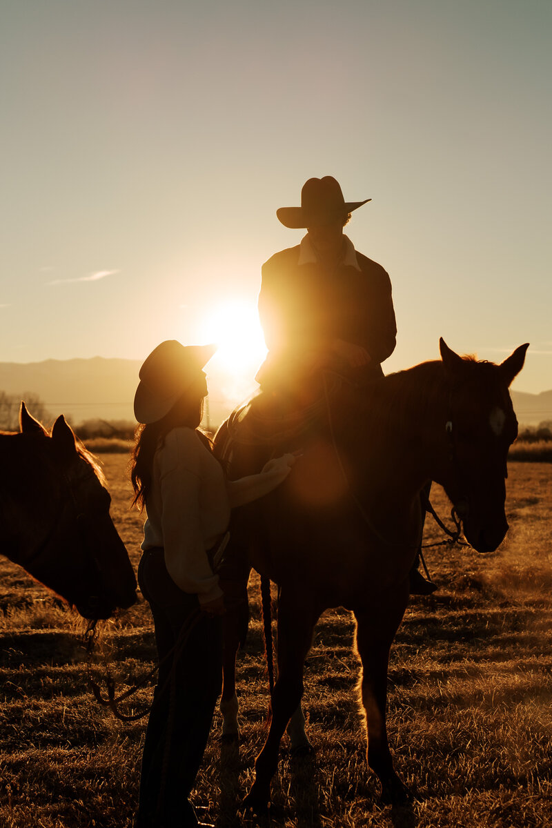 Western couples session with two riders on horseback surrounded by fall colors in the mountains