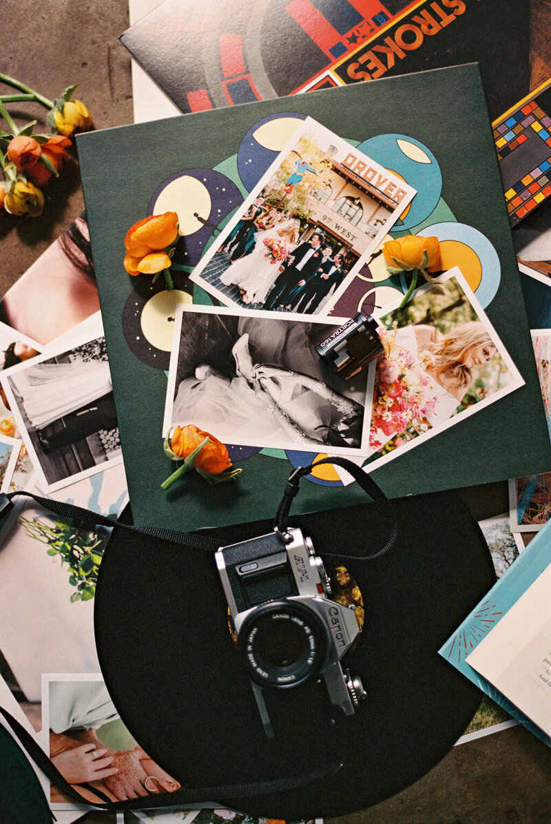 Flash film photo of a film camera, printed photos, records, and flowers