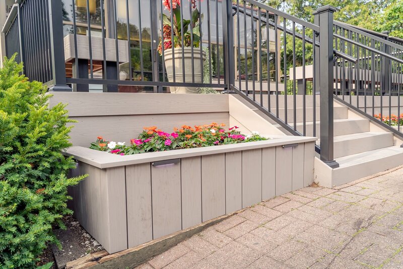 Flower bed made from TimberTech Advanced PVC decking and filled with bright flowers in the summertime. 