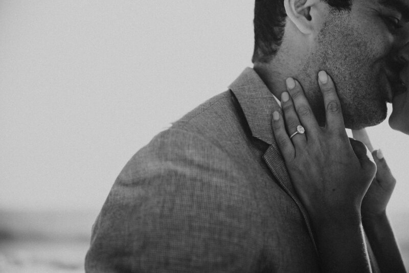 brides hands on grooms face kissing in Malibu