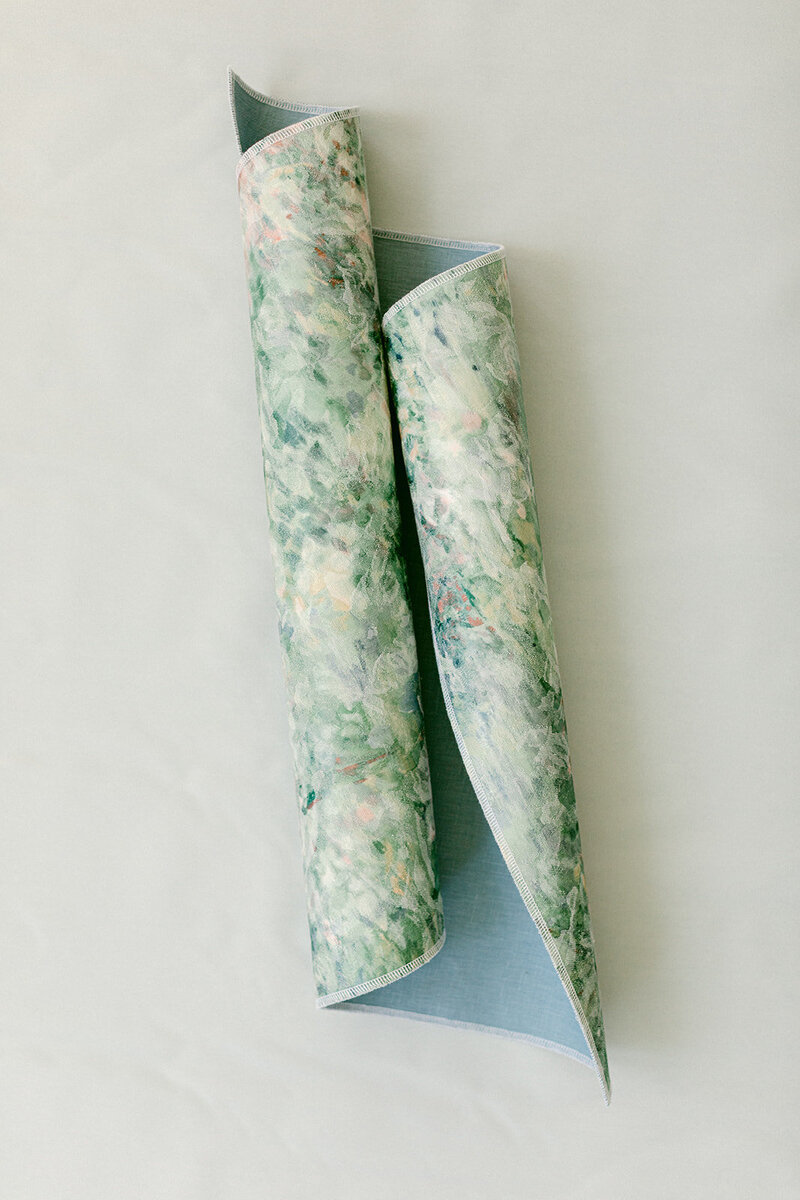 Soft blue linen flat lay mat styled with romantic paper goods and silk ribbon