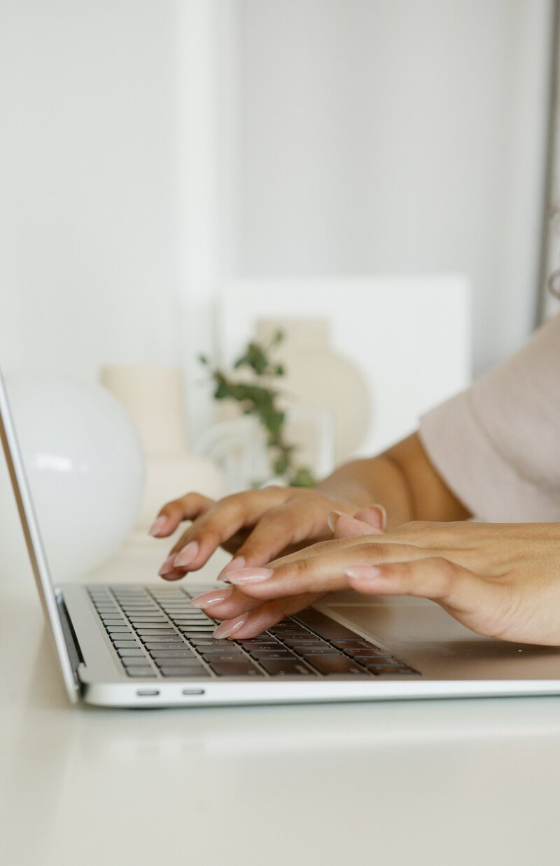 Woman's hands typing on a laptop keyboard