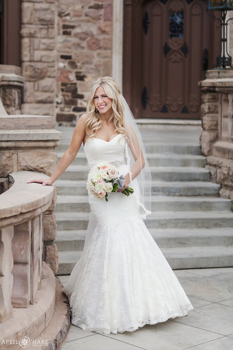 Beautiful blonde bride poses on the Front Veranda outside of the Highlands Ranch Mansion in Colorado