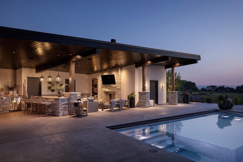 Outdoor poolhouse complete with an outdoor kitchen, outdoor furnishings and light fixtures. 